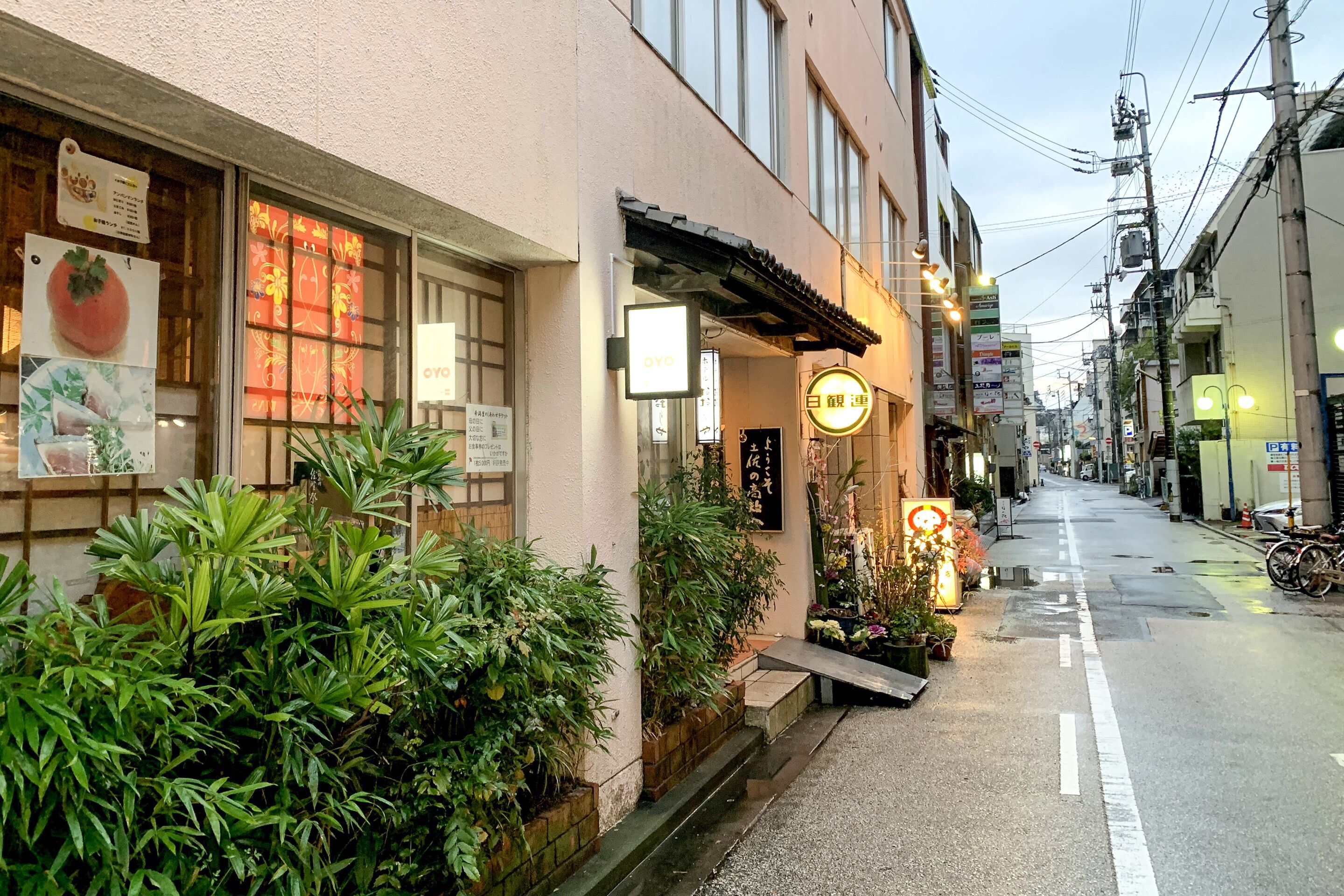 A street view of a building with a signboard, a window display, and a street lamp.