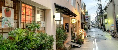 A street view of a building with a signboard, a window display, and a street lamp.