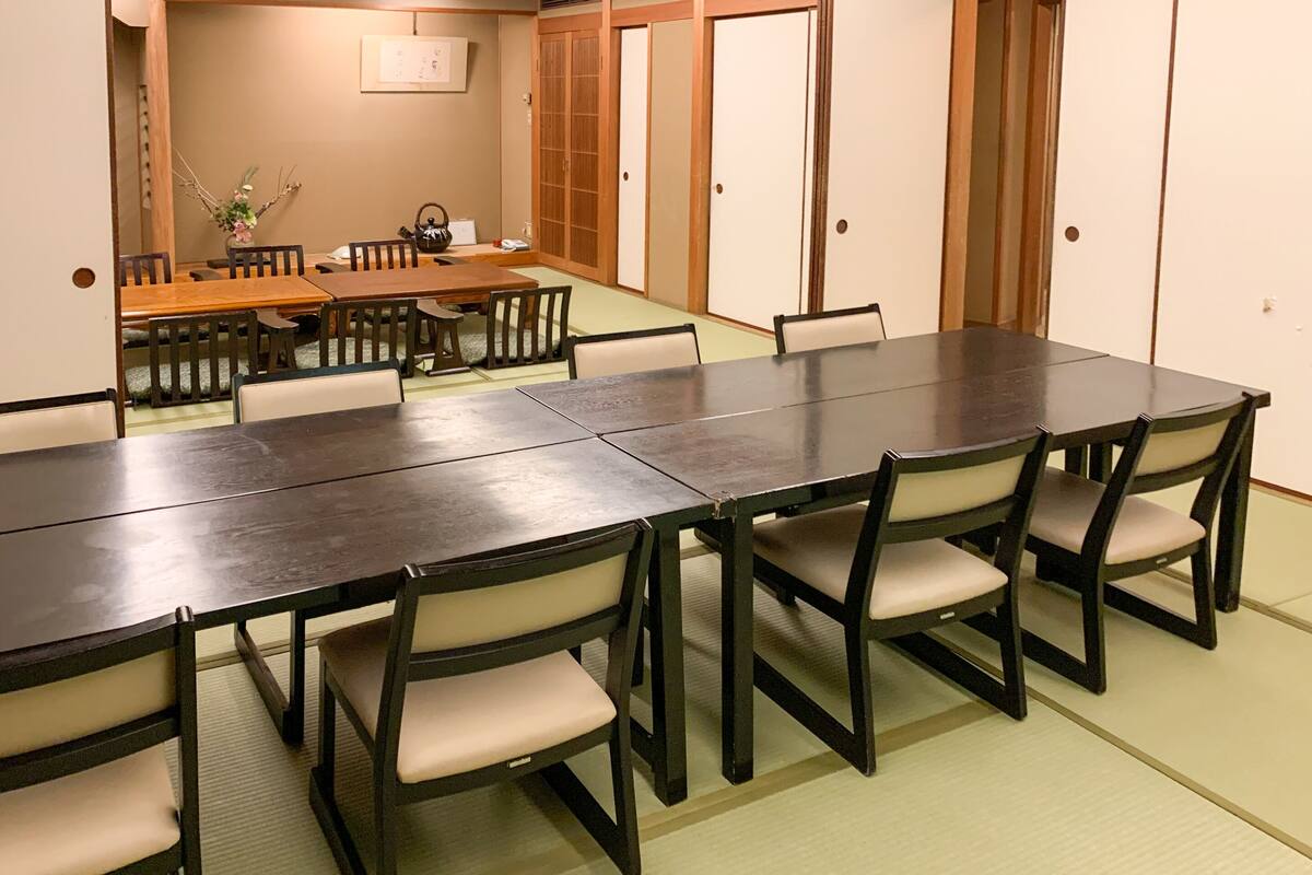 A traditional Japanese-style room with tatami flooring, a low table, and wooden sliding doors.