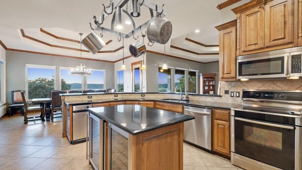 Una cocina moderna con una isla central, electrodomésticos de acero inoxidable y armarios de madera.