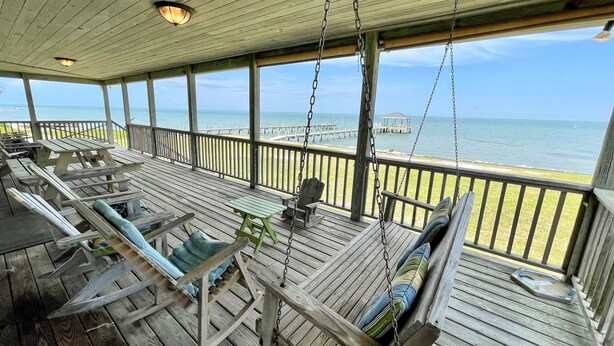 A wooden deck with seating and a view of the ocean. - Old Pamlico Inn Site:  Large waterfront home with dock, amazing views (Ocracoke)
