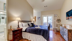 Un dormitorio con cama, cómoda, silla y vistas al exterior.