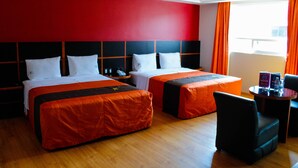 Una habitación de hotel con dos camas, un escritorio y una silla.