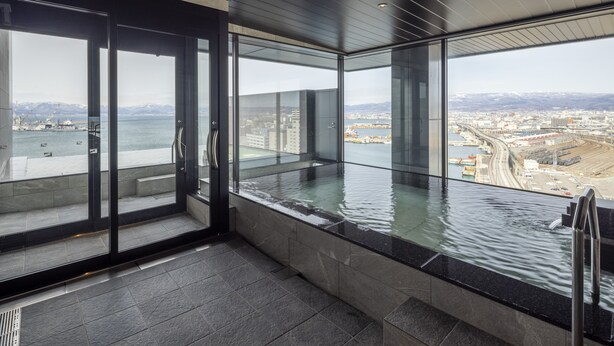 A modern interior with large glass windows offering a view of a body of water and a cityscape. - Tokyu Stay Hakodate Asaichi Akarinoyu (Hakodate)
