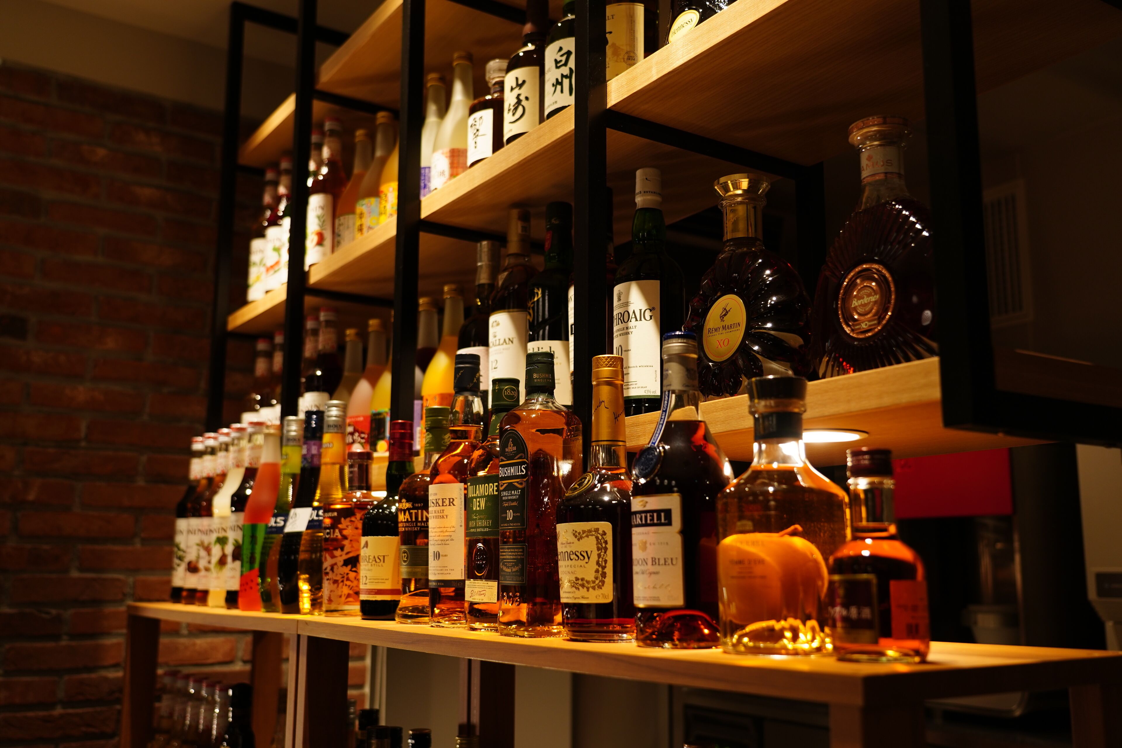 A bar with shelves stocked with various liquor bottles.