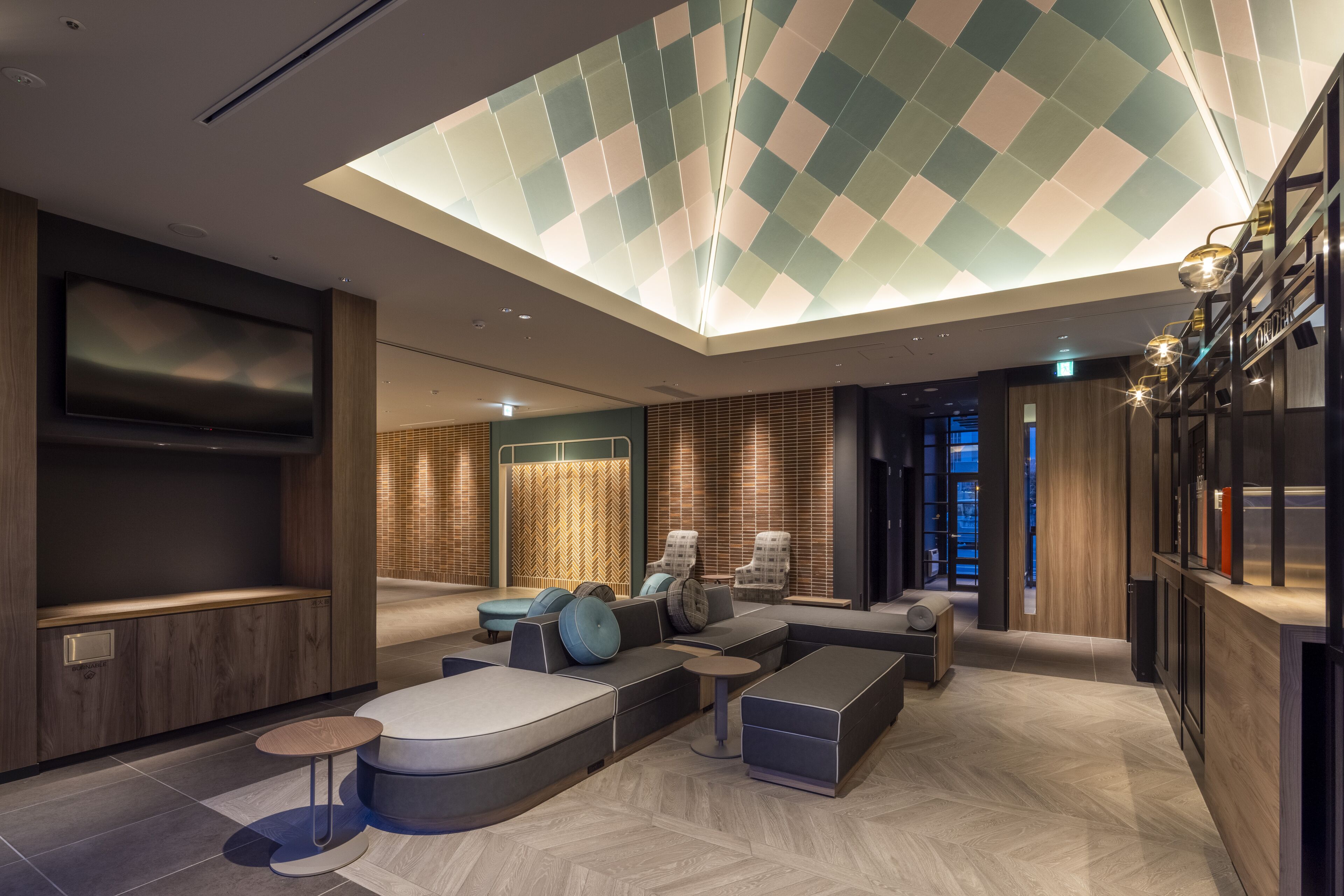 Un'area lounge moderna con ampie sedute, una televisione a schermo piatto e un soffitto con finestra a lucernario.