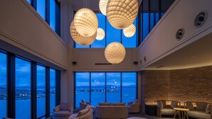 A spacious lounge with large windows, a high ceiling, and modern lighting fixtures. - Tokyu Stay Hakodate Asaichi Akarinoyu (Hakodate)
