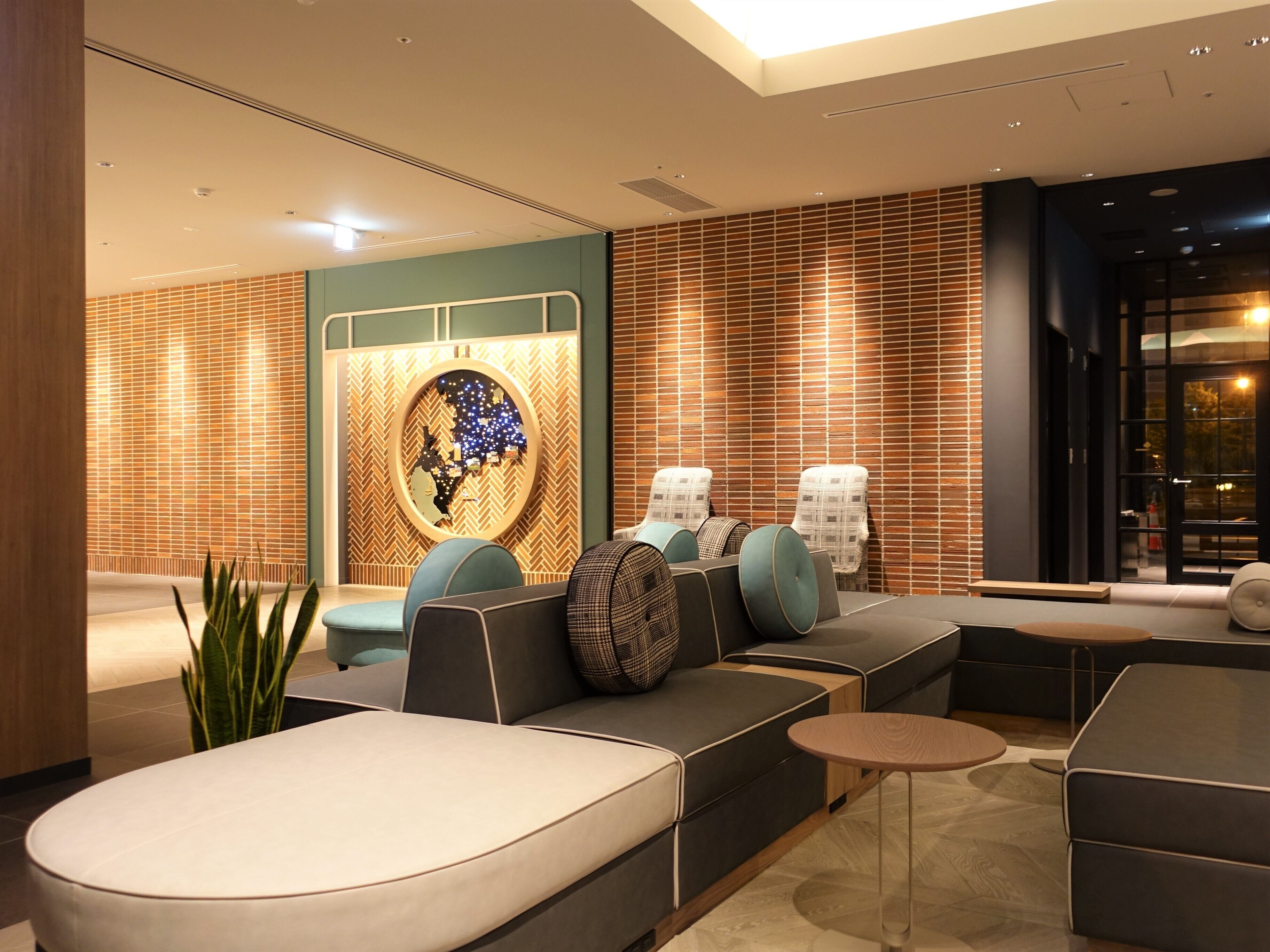 A modern lounge area with a sofa, armchairs, and a small table.