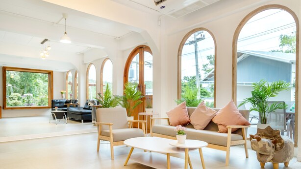 A spacious living area with a sofa, chairs, a coffee table, and a decorative pig statue.