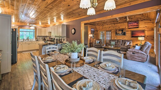 Un acogedor interior de cabaña con comedor, cocina y sala de estar.