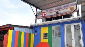 Ein buntes Gebäude mit einem großen Banner, das eine Kaffeemarke bewirbt.