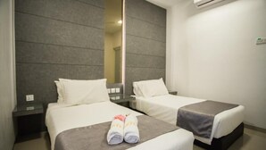 Ein Hotelzimmer mit zwei Betten, einem großen Spiegel und einer Klimaanlage.