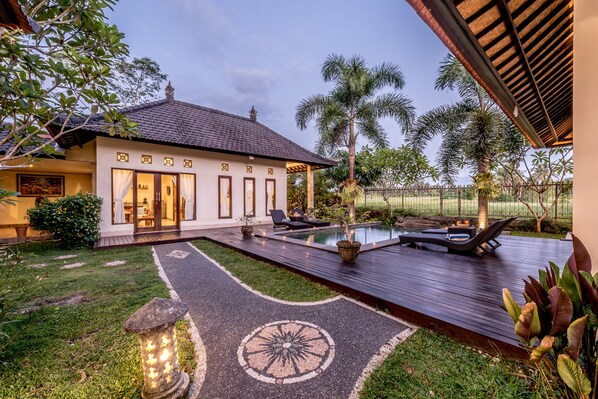 A house with a swimming pool, a deck, and a garden.