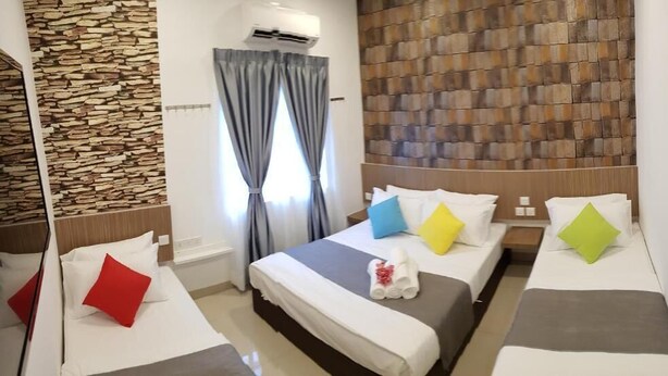 A hotel room with three beds, a stone wall, and a modern design. - Casa 96 Villa (Kuantan)