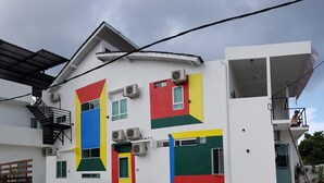 A white building with colorful geometric window designs and a visible staircase. - Casa 96 Villa (Kuantan)
