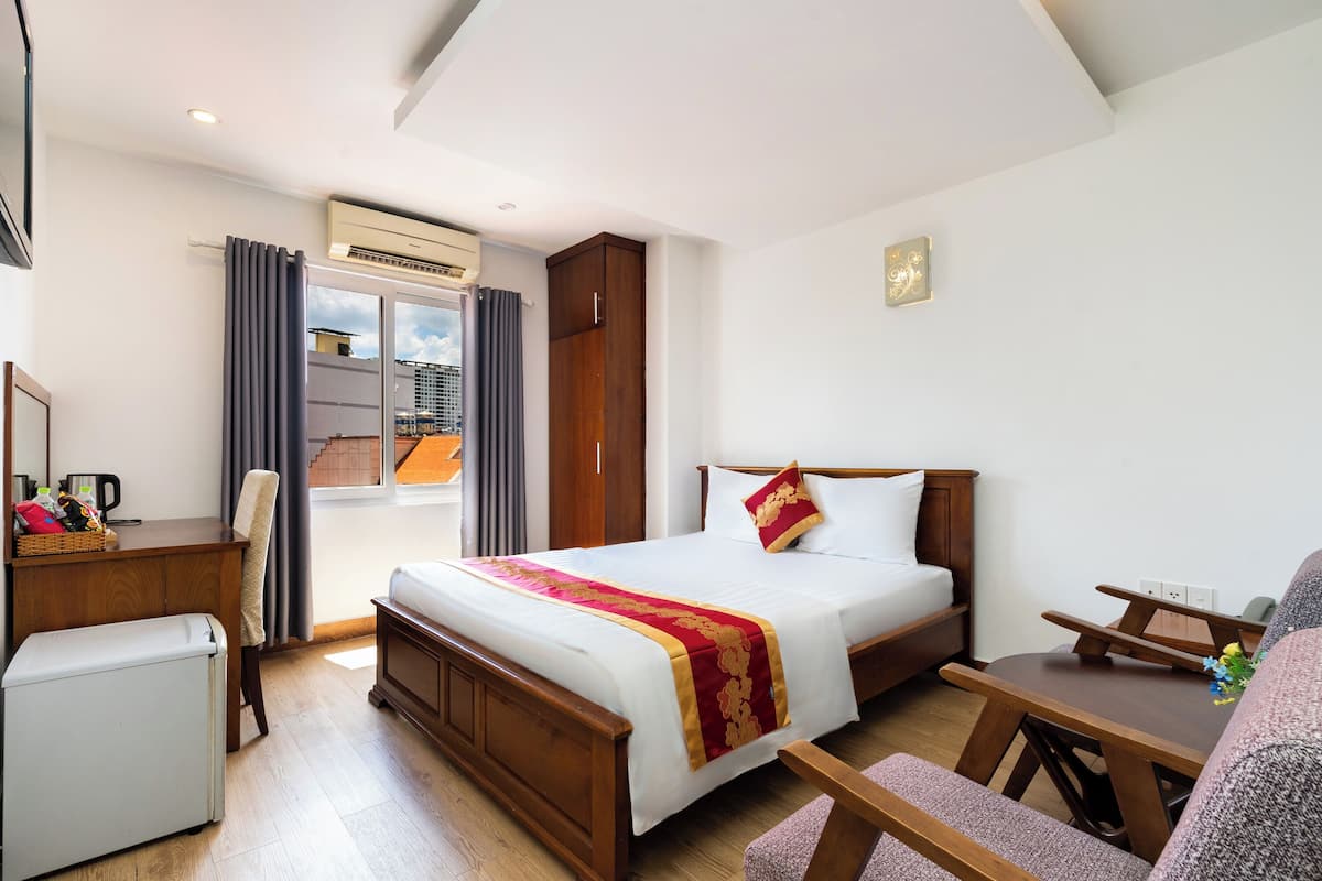 Une chambre d’hôtel avec un grand lit, un bureau, une chaise et une petite table.