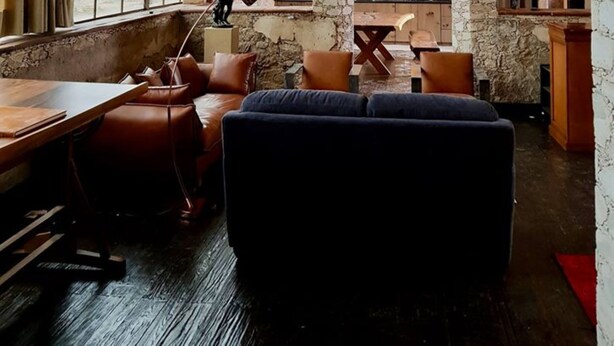 A rustic interior with stone walls, a large window, and a chandelier. - Mineral del Cielo (Pozos)