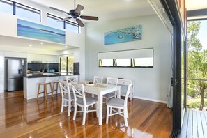 Eine moderne Küche mit Essbereich, Holzboden, Deckenventilator und Kunstwerken an den Wänden.
