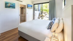 Un dormitorio con cama, ventilador de techo y vistas al exterior.
