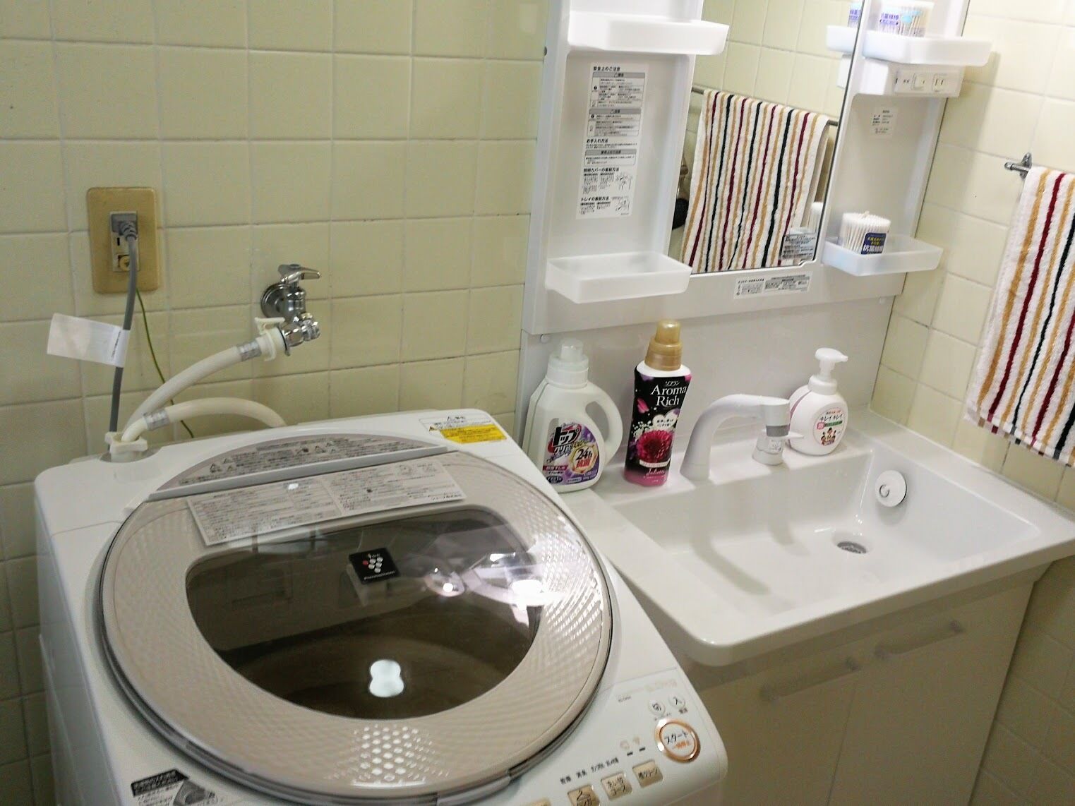 Ein Waschraum mit Waschmaschine, Spüle und Pflegeprodukten.