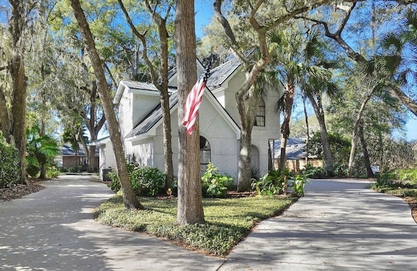 A residential street with houses, trees, and a sidewalk.