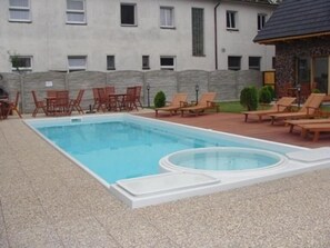 Een seizoensgebonden buitenzwembad, parasols voor strand/zwembad