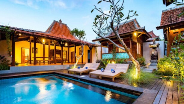 A pool area with lounge chairs and a wooden deck.