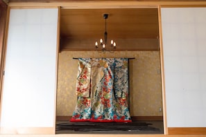 Une pièce avec un plafond en bois, un lustre et un rideau traditionnel aux couleurs vives.