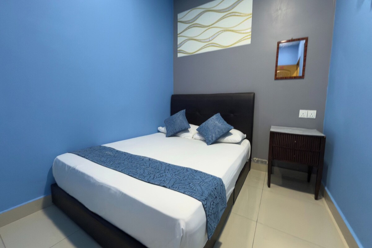 A bedroom with a bed, a nightstand, a wall-mounted picture, and a wall with a wavy pattern.
