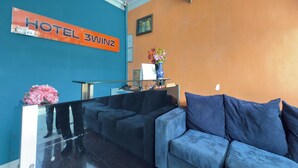 A hotel reception area with a blue wall, a reception desk, a blue sofa, and a sign that reads "HOTEL 3WINZ". - Hotel 3Winz, Chow Kit Kuala Lumpur (Kuala Lumpur)