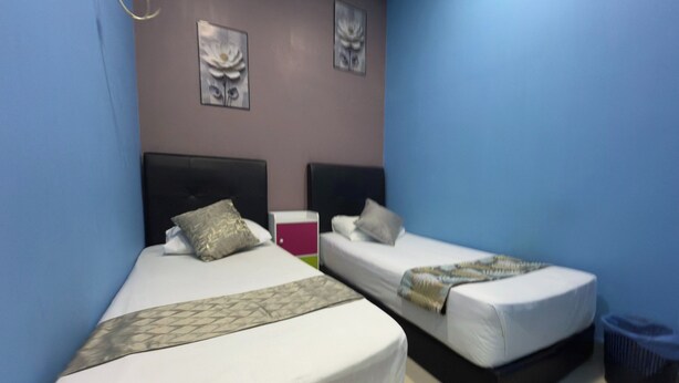 A hotel room with two beds, a trash bin, and artwork on the walls. - Hotel 3Winz, Chow Kit Kuala Lumpur (Kuala Lumpur)