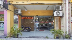 A hotel entrance with a sign reading "HOTEL3WINZ". There are air conditioning units mounted on the exterior wall, and a motorcycle parked in front. - Hotel 3Winz, Chow Kit Kuala Lumpur (Kuala Lumpur)