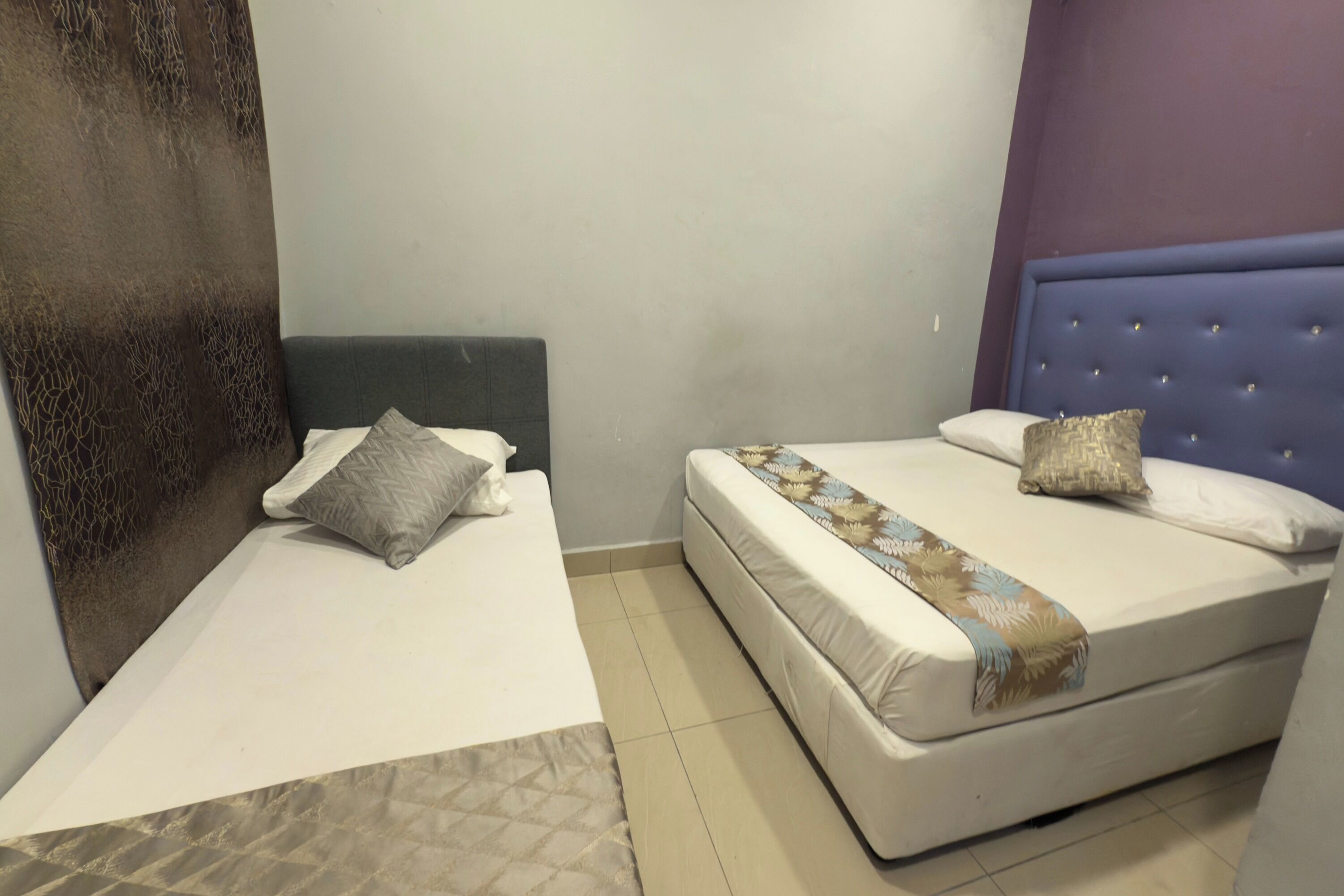 Une chambre avec deux lits, dont l’un est doté d’une tête de lit et l’autre non.