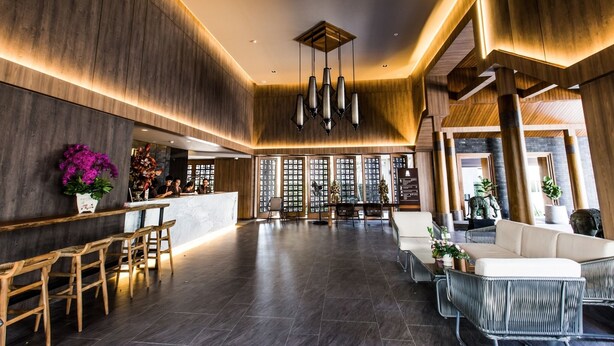 A spacious lobby with a reception desk, seating area, and a modern chandelier. - The Teak Hotel (Mae Sot)