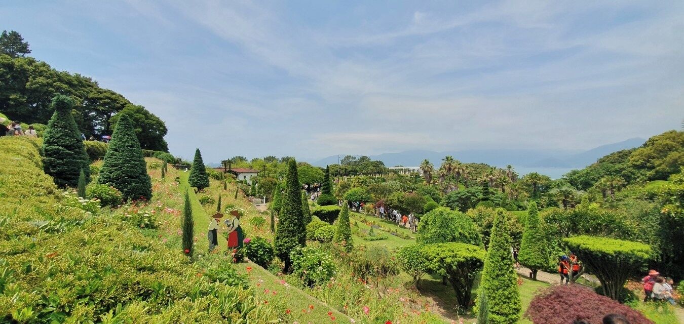 Un jardin luxuriant, avec des haies soigneusement taillées et une grande variété d’arbres.