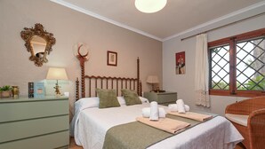 A well-lit bedroom with a bed, bedside tables, a dresser, a window with a view, and a decorative mirror. - Ginjoler 4 pax - Javea, Costa Blanca (Javea)