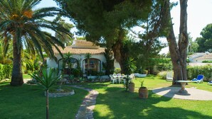 A house with a stone pathway leading to a patio area with outdoor furniture. - Ginjoler 4 pax - Javea, Costa Blanca (Javea)