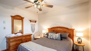A bedroom with a wooden bed, two bedside lamps, a ceiling fan, a dresser, and a mirror. - Bear Hug Inn - 74 Lower Lane

Bear Hug Inn - Pet Friendly, Wood Fireplace (Davis)