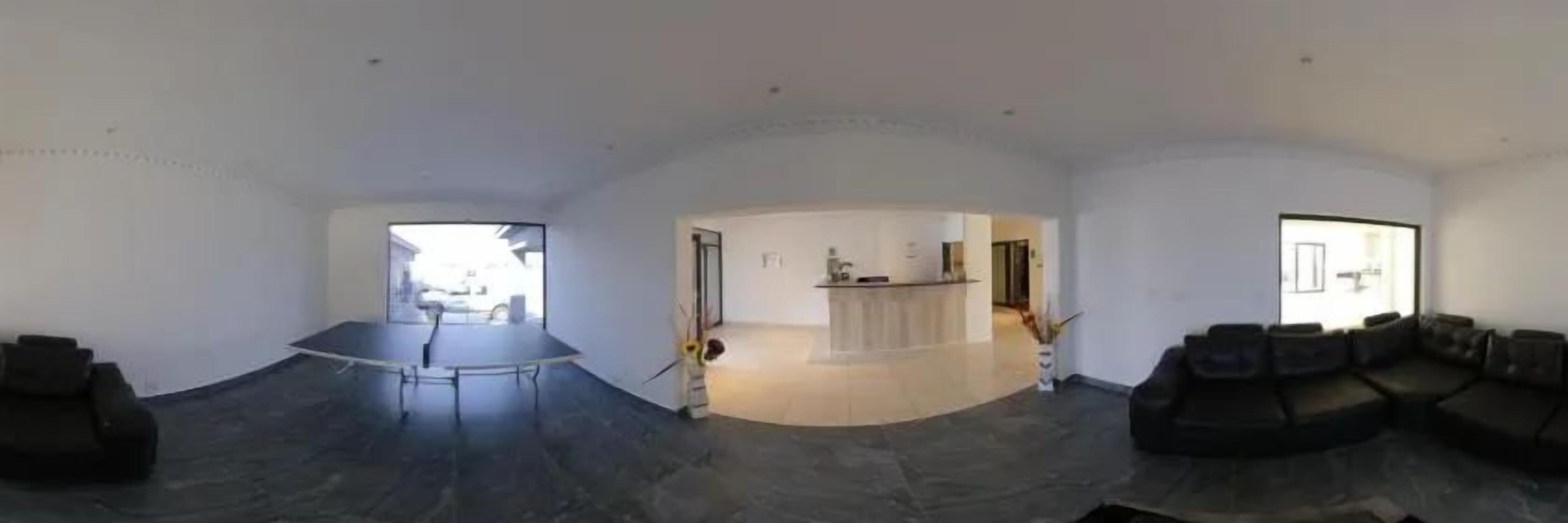 A spacious room with a large seating area, a reception desk, and a view of the outside.