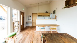 Une cuisine spacieuse dotée d’un plancher en bois, d’un îlot central et d’un coin repas avec deux chaises.
