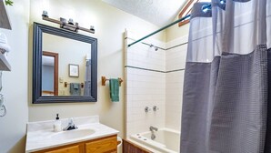 A bathroom with a wooden vanity, a mirror, a shower with a glass door, and a towel rack. - Unwind at Quiet Snow - Mountain Retreat w/ Hot Tub (Davis)