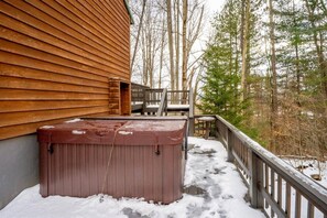 A wooden deck with a hot tub and a chair, surrounded by snow and trees. - Unwind at Quiet Snow - Mountain Retreat w/ Hot Tub (Davis)