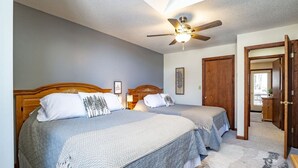 A bedroom with two beds, a ceiling fan, and a door leading to another room. - Unwind at Quiet Snow - Mountain Retreat w/ Hot Tub (Davis)