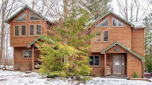 A two-story wooden cabin with a green roof, a front porch, and a sign that reads 'Quiet Cabin.' - Unwind at Quiet Snow - Mountain Retreat w/ Hot Tub (Davis)