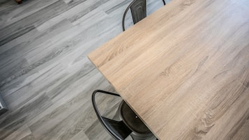 Un tavolo in legno con sedie in metallo in una stanza con pavimento in legno grigio.