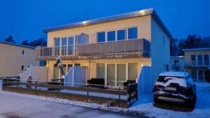 A modern two-story building with a balcony and a car parked in front. - * Coastal Oasis - Wilke GM 69934 - * Coastal Oasis - Wilke SNR .: 8 (Gelbensande)