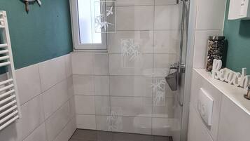 Ein Badezimmer mit Dusche, Toilette und Waschbecken.