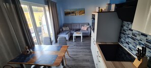 Un espace de vie compact comprenant une table à manger, un canapé et une kitchenette.