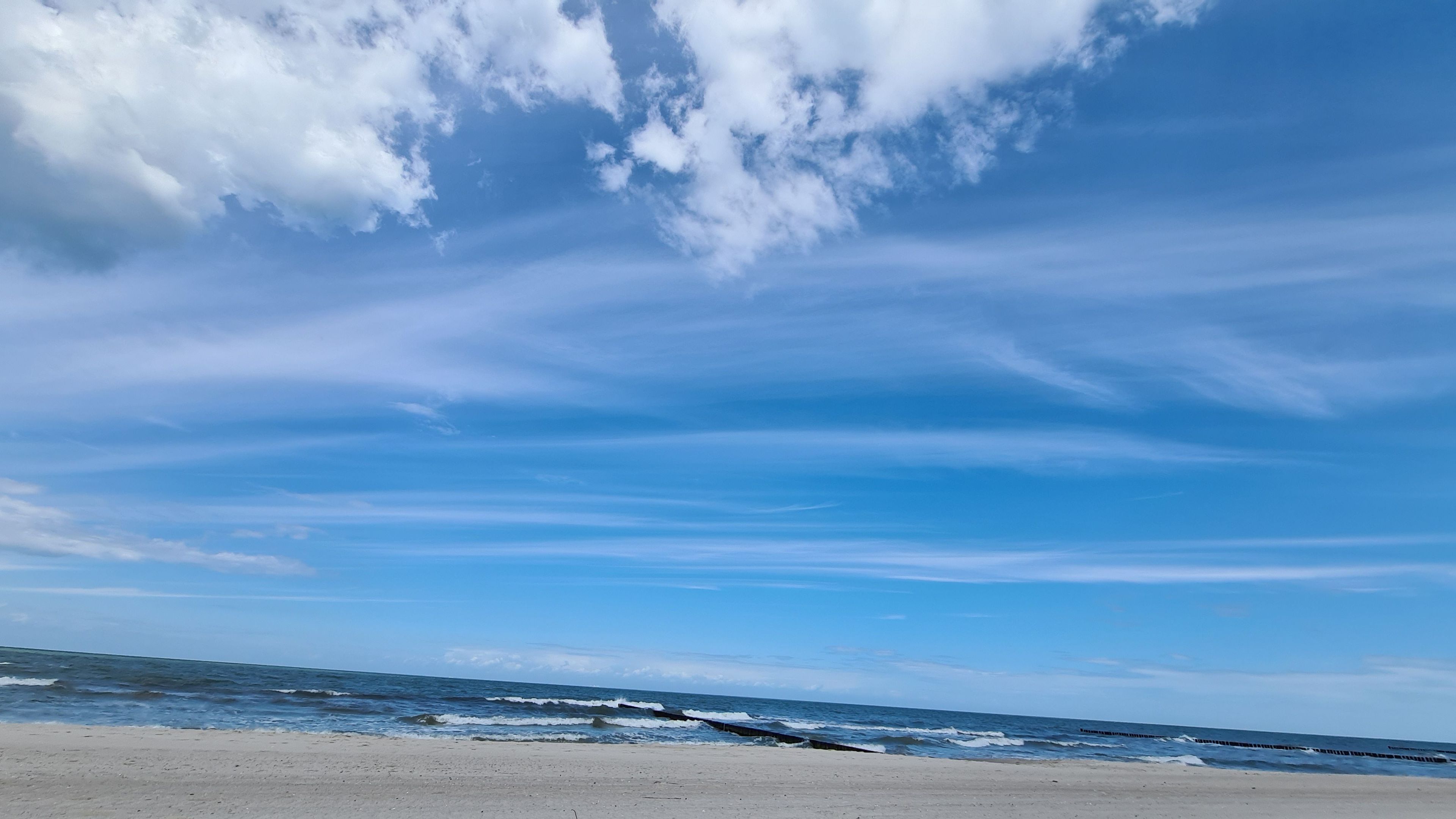 Ein Strand mit blauem Himmel und Wellen.