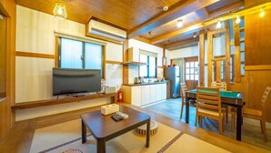 A cozy living room with a TV, a small table, and a dining area with a table and chairs. - Suehirodori Japanese Entire Home No2 (Tainan)